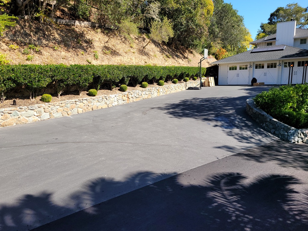 Finished asphalt driveway in front of a residential garage