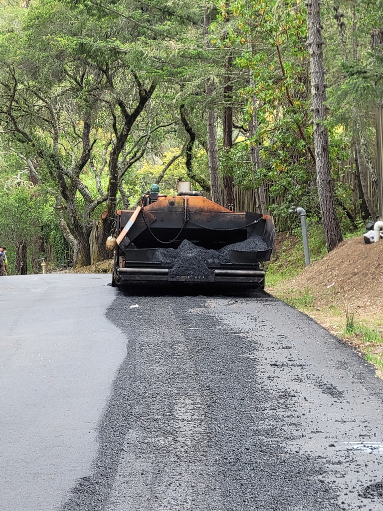 Paving machine applying asphalt on a private road