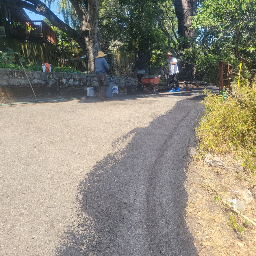 Crew using slurry to level and patch damaged asphalt areas